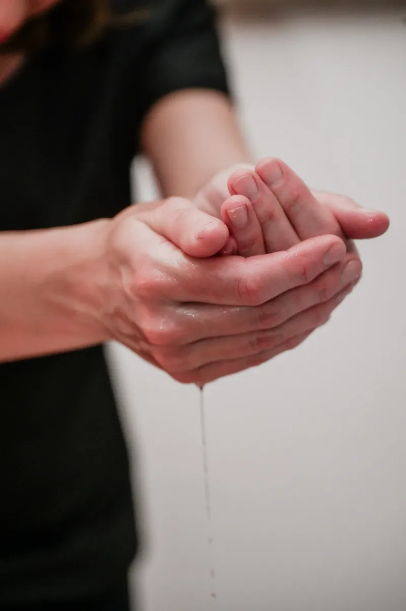 Hände mit Öltropfen für die Aroma-Massage
